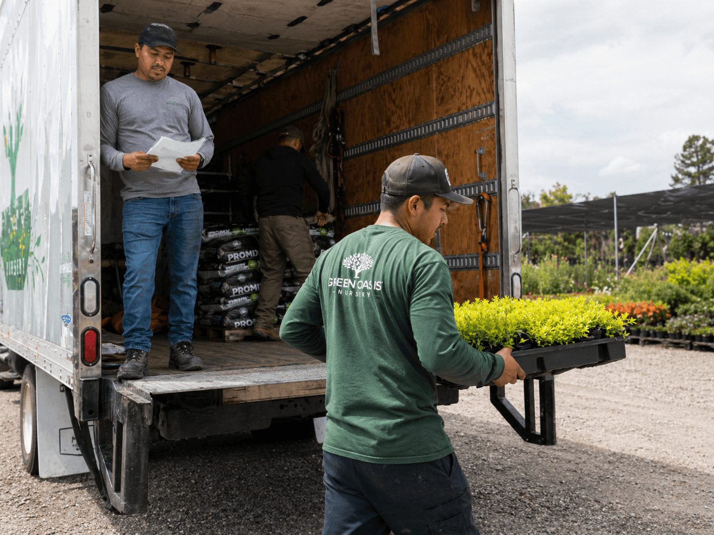 Maintenance crew loading plants from a nursery truck for the day's route